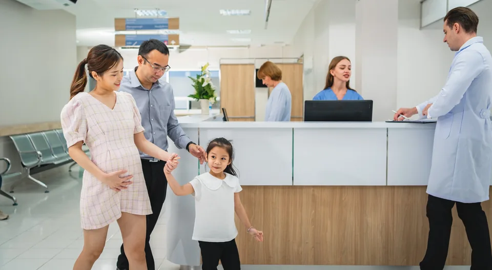 A family arriving at a hospital reception desk