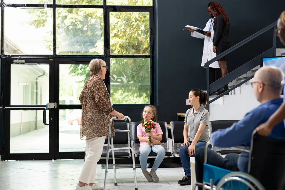 Visitors in a hospital waiting area, including people using mobility aids
